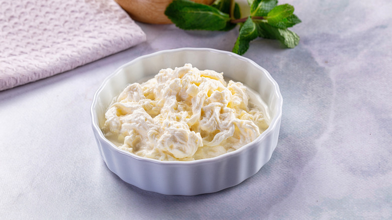 Ramekin full of stracciatella, mint and cloth napkin in background