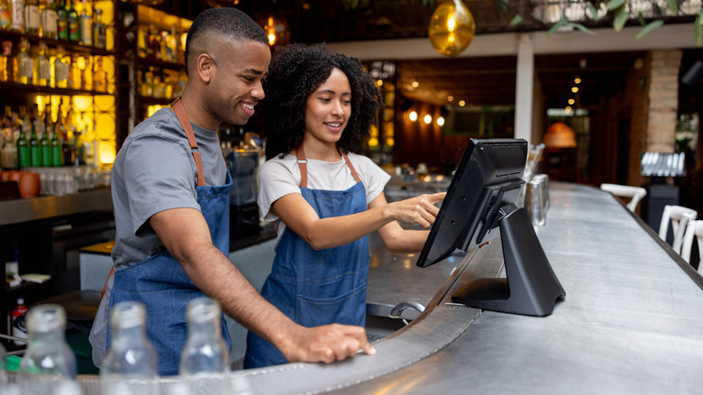 Two people at a restaurant till