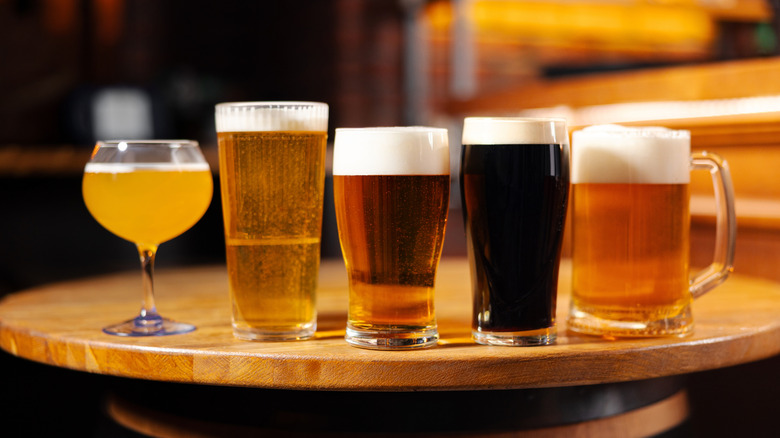 Assorted styles of beer in different glasses on wooden table
