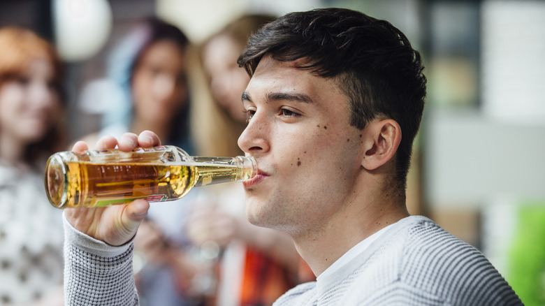 Man drinking a bottle of beer outside