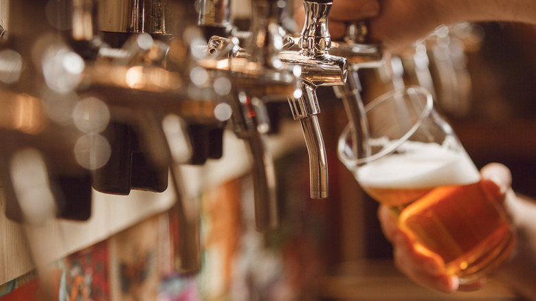 Person pouring beer from a tap into a glass