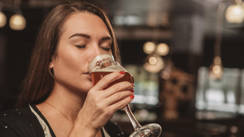 Woman sipping a beer from a glass