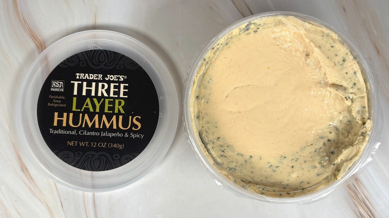 Top-down shot of open container of Trader Joe's Three Layer Hummus