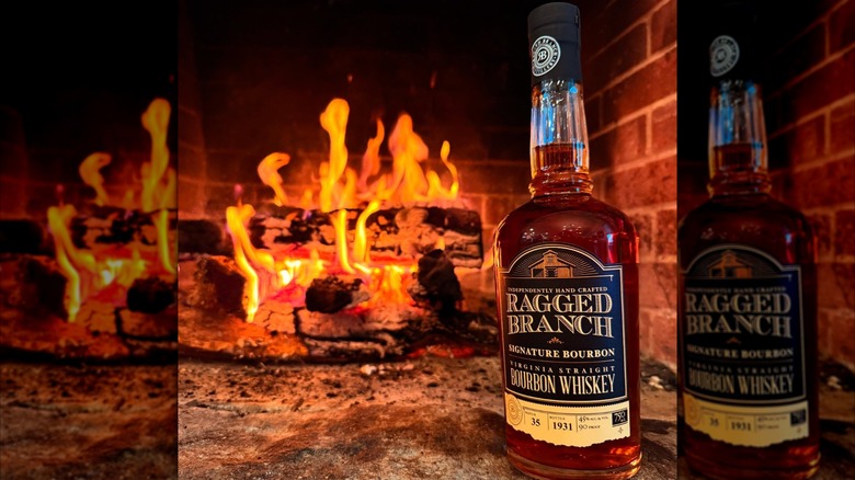 bottle of ragged branch bourbon in front of a fire at the distillery