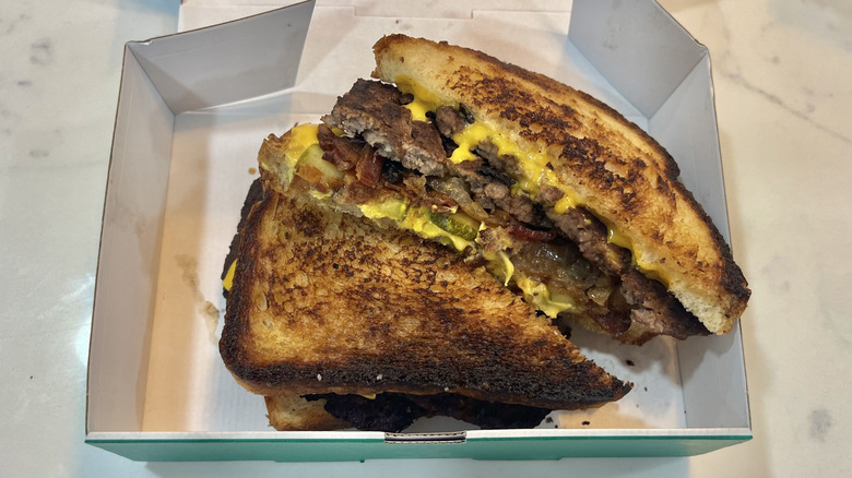 Wahlburgers The Super Melt burger in to-go box.