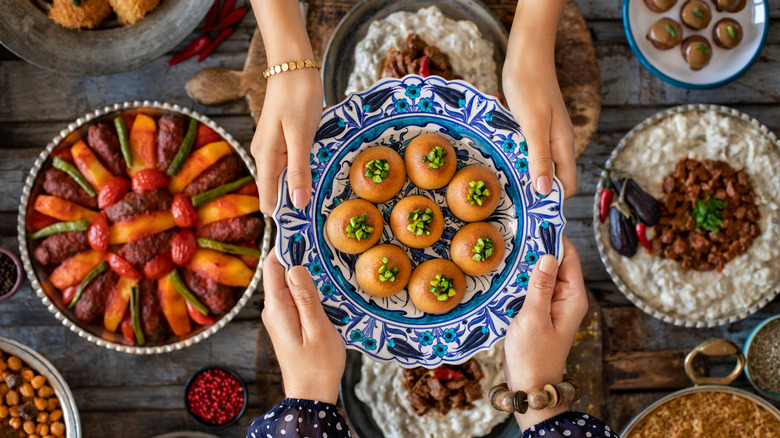 Plate of food being passed between two sets of hands