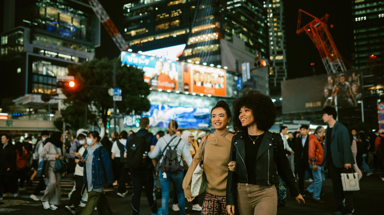 Two woman walking down a busy street in Tokyo, Japan