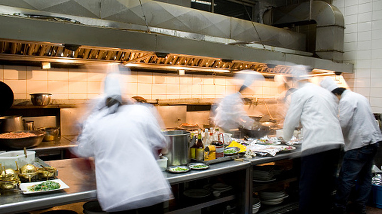 Chefs in motion, working in a sleek open kitchen