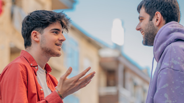 Two young men talking outside