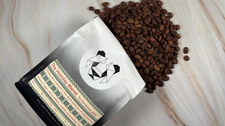 Top-down shot of coffee beans spilling out of bag of Black & White holiday blend