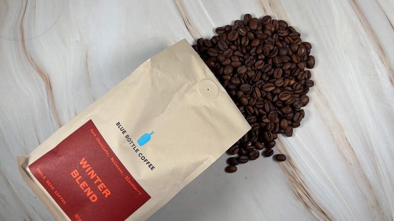 Top-down shot of coffee beans spilling out of bag of Blue Bottle holiday blend