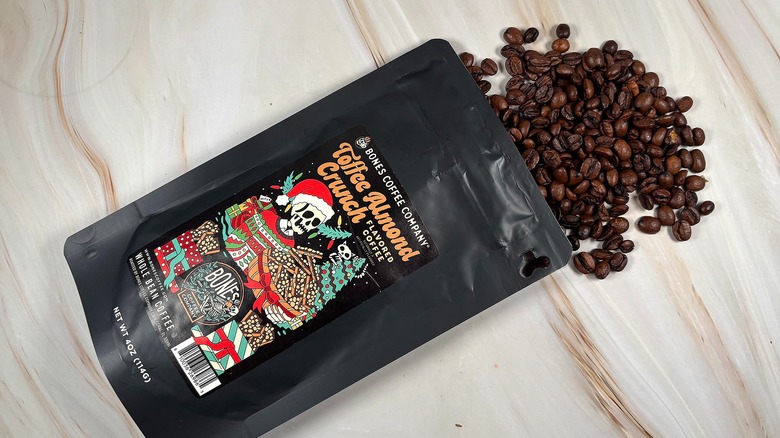 Top-down shot of coffee beans spilling out of bag of Bones Coffee Co holiday blend