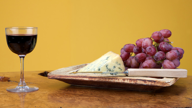 A glass of Port wine and a plate of blue cheese and grapes