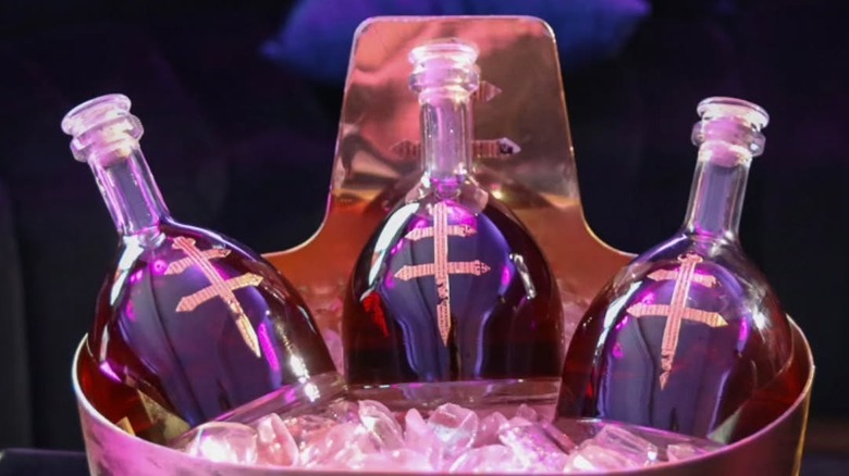 Three bottles of D'Ussé Cognac resting in a large bucket of ice