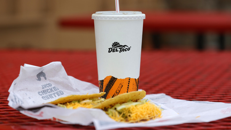 Del Taco taco and drink on red table