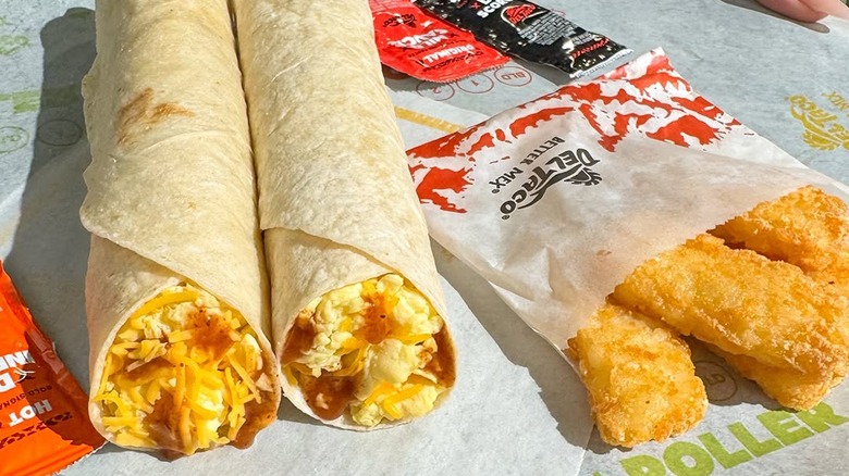 A breakfast burrito meal with hash browns on a tray from Del Taco