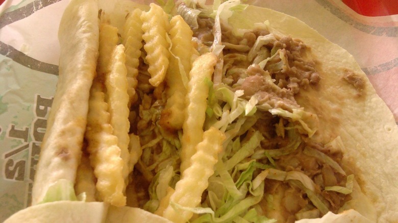 An open face Stoner Burrito from Del Taco atop a branded wrapper