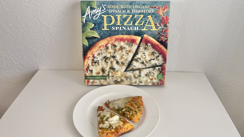 Amy's Spinach pizza box and slices on a plate all laid on a white table