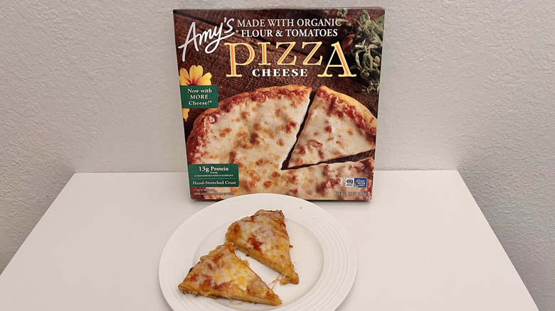 Amy's cheese pizza box and two slices served on a white plate in front