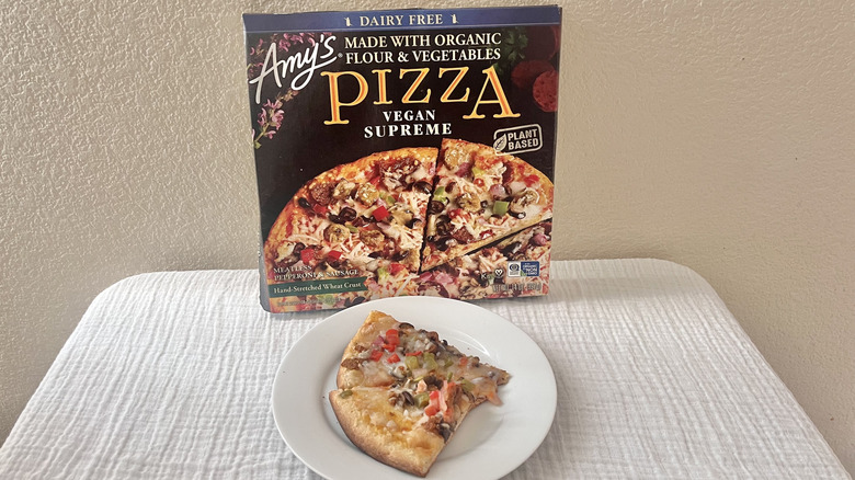 Dairy Free Vegan Supreme Amy's pizza slices on plate with the box stacked against a wall
