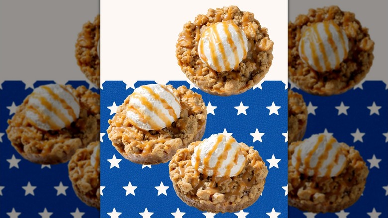 Three Caramel Apple Crisp Cookies from Crumbl against white and blue star patterned background