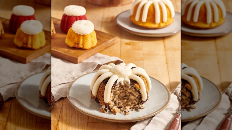 Various miniature bundt cakes with icing from Nothing Bundt Cakes on white plates and wooden board