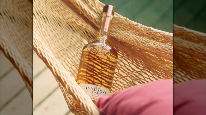 A bottle of Codigo 1530 Rosa on a hammock