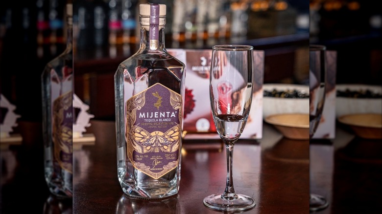 Bottle of Mijenta Maestra Selection next to a flute