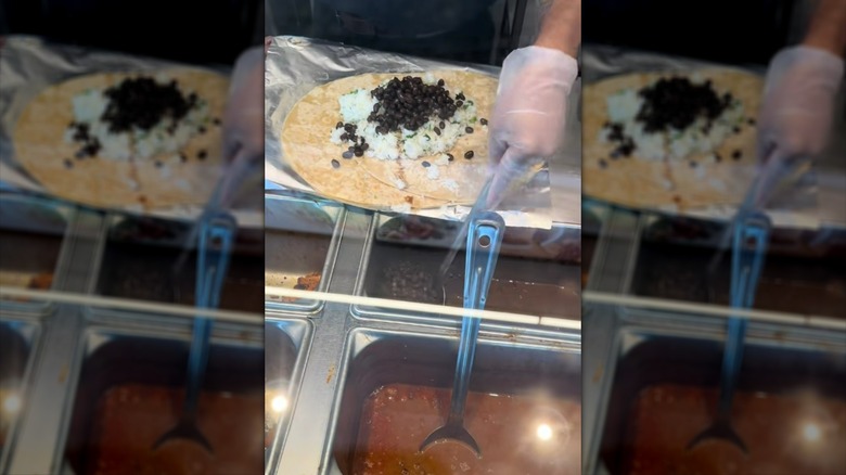 Chipotle worker preparing double-wrapped burrito