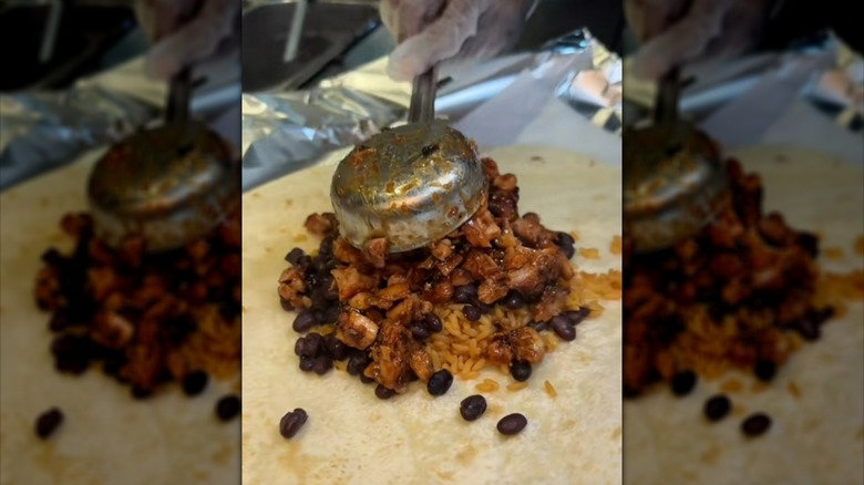 Scooping honey chicken onto tortilla wrap with rice and beans