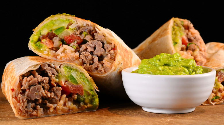 Beef burrito served with bowl of guacamole