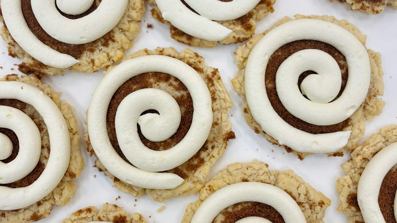 Tray of cookies topped with swirled white icing and cinnamon