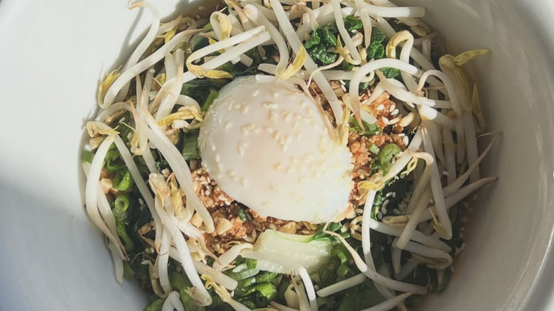 Noodle bowl with bean sprouts, chili crisp, herbs, and poached egg