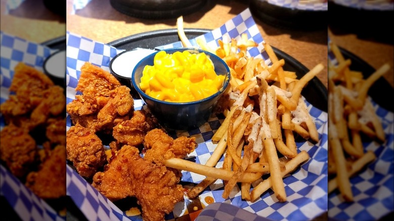 Wings, macaroni and cheese, and fries in basket on table