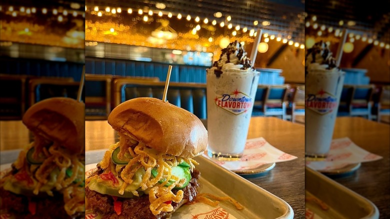 Burger and milkshake with Downtown Flavortown logo on table