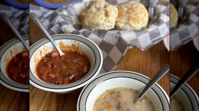 Chili, white bean soup, and biscuits on table
