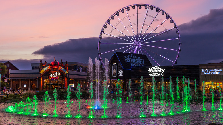 Evening view of water fountain and Ferris wheel on The Island in Pigeon Forge, where restaurants abound