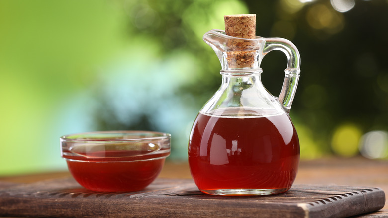 Maple syrup in bottle and bowl on cutting board