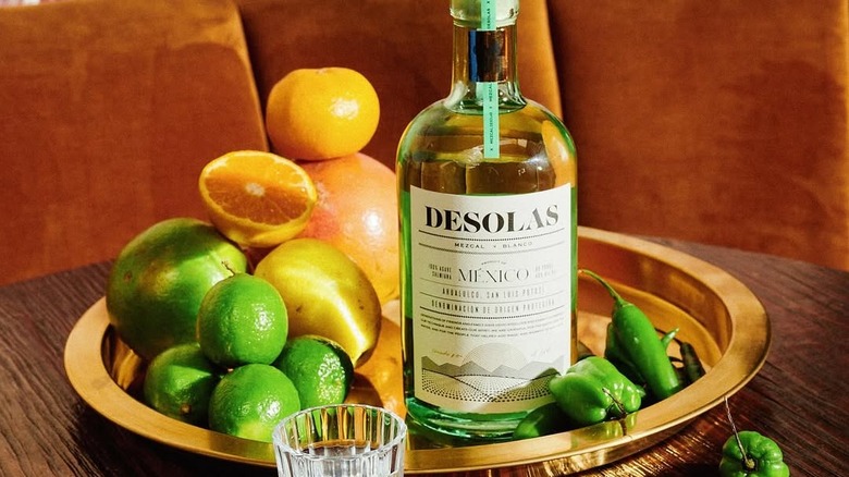 Bottle of Desolas Mezcal and tray of citrus