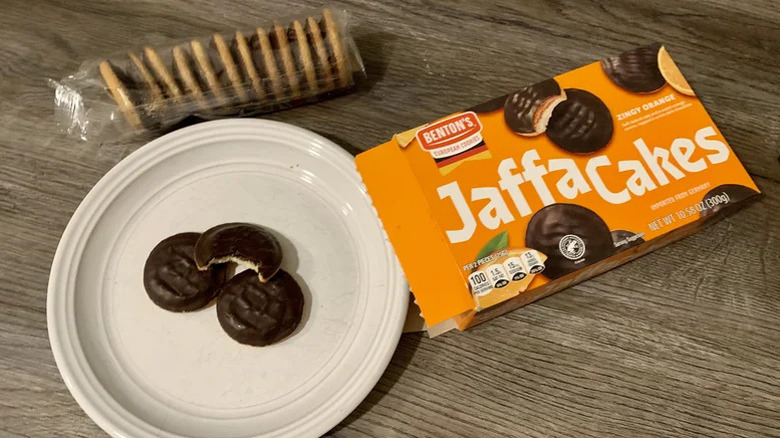 Three Jaffa Cakes on a plate alongside the packaging