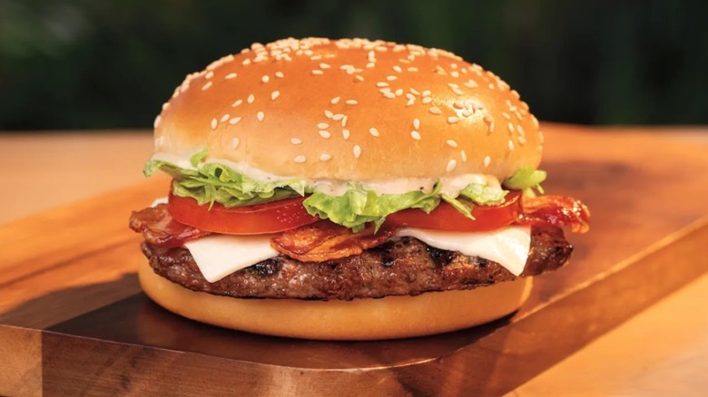 Burger King Peppercorn BLT Whopper burger sitting on wooden board