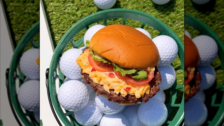 Shake Shack Clubhouse Pimento Cheese Burger arranged on top of golf balls in green plastic bucket