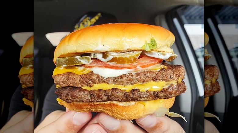 Hands holding Wendy's Jalapeño Ranch Cheeseburger