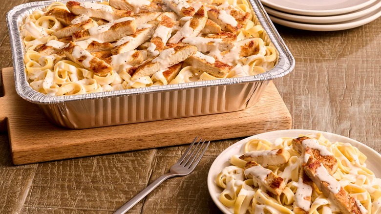 Chicken Alfredo catering dish with a portion on a plate