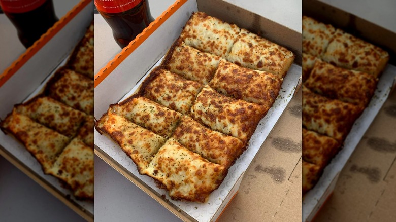 Rectangular Italian cheese bread in cardboard takeout box