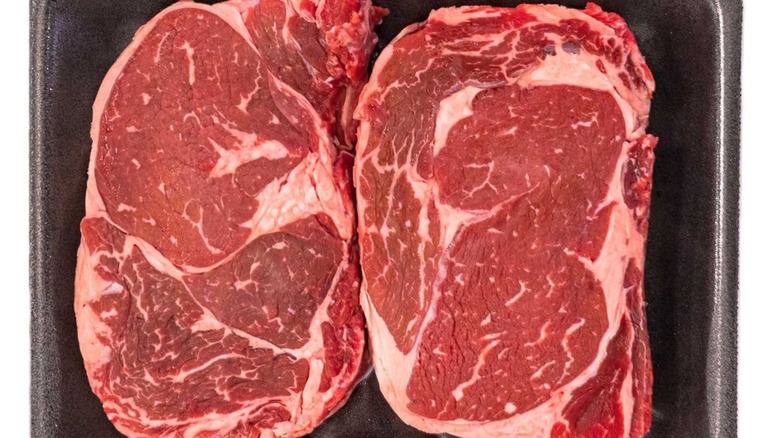 Two Member's Mark USDA Choice Angus beef boneless ribeye steaks in a black tray