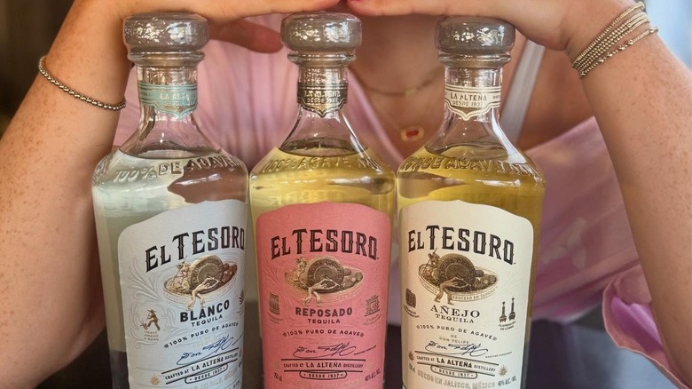 Three bottles of El Teroso tequila in front of a woman