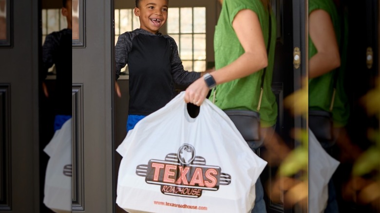 happy child with Texas Roadhouse takeout order