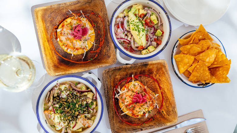 Colorful spread of tacos and chips with glass of white wine