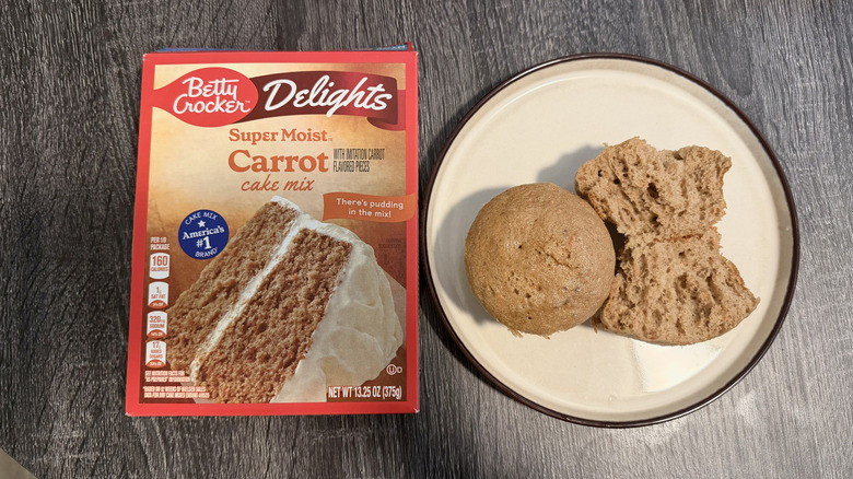 Left: a box of cake mix; right: two light brown cupcakes, one halved